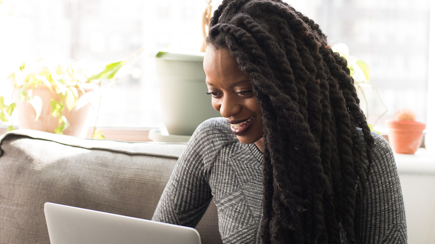 Woman on laptop at home smiling